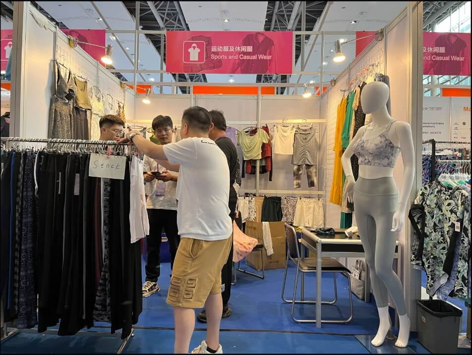 A client examining a legging's stitching quality at the LJ Garment booth