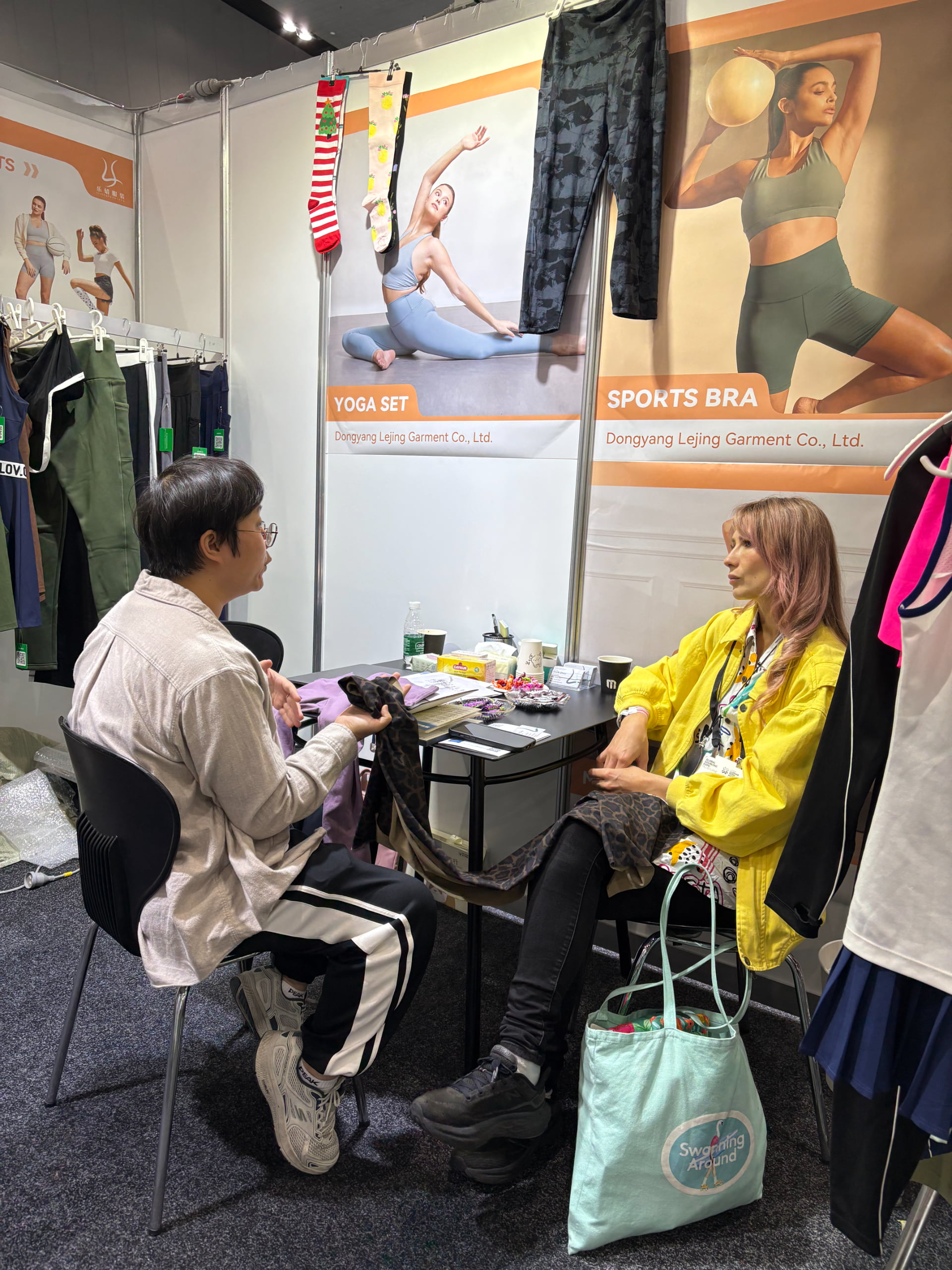 Professional factory sales representative holding a yoga legging sample during client meating